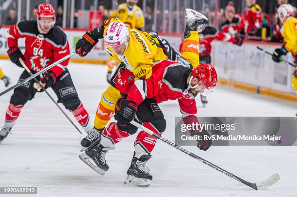 Joel Vermin of SC Bern trips over Jason Fuchs of Lausanne HC during the Swiss National League game between Lausanne HC and SC Bern at Vaudoise Arena...