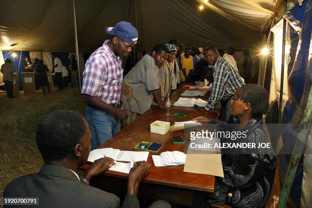 Zimbabwean voters wait at a polling station in Harare 10 March 2002 after the official closing hour of 7:00 pm on the scheduled last day of the...