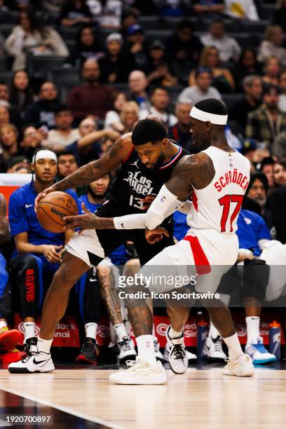 Clippers forward Paul George against Toronto Raptors guard Dennis Schroder during a NBA basketball game on January 10, 2024 at Crypto.com Arena in...