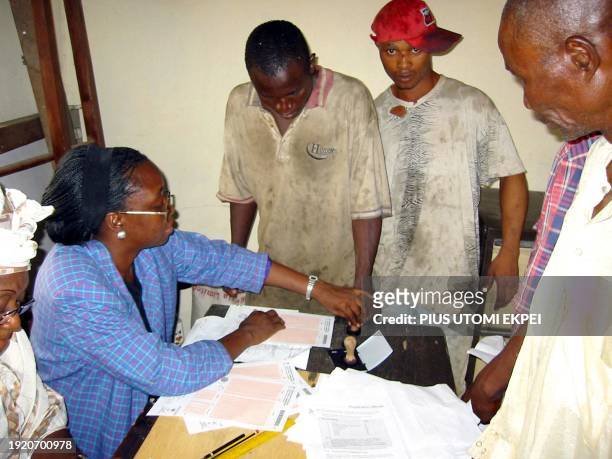 An official of the Independent Electoral Commission guides a voter to place his thumb print on the registration paper 21 January, 2003 in Lagos. The...