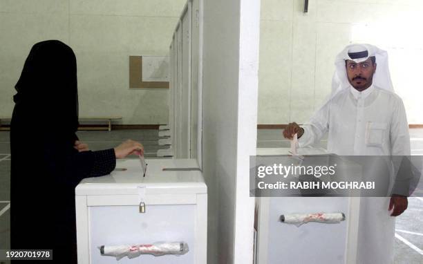 Qatari couple casts their votes during local elections in Qatar 08 March 1999 in Doha. It is the first time women go to the polls in the Gulf to...