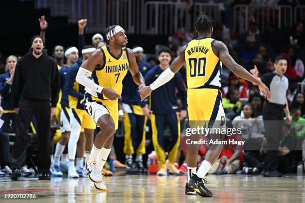 Buddy Heild and Bennedict Mathurin of the Indiana Pacers high five during the game against the Atlanta Hawks on January 12, 2024 at State Farm Arena...