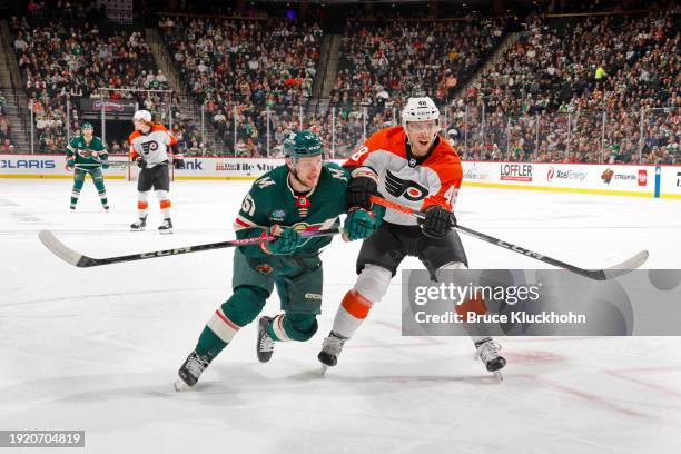 Adam Raska of the Minnesota Wild collides with Morgan Frost of the Philadelphia Flyers during the first period of the game at the Xcel Energy Center...