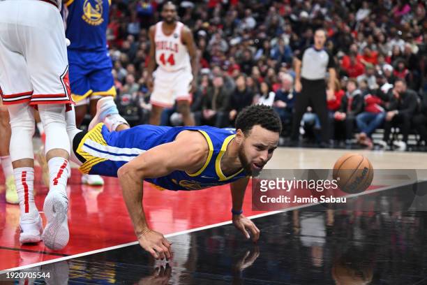 Stephen Curry of the Golden State Warriors falls to the floor after losing control of the ball in the second half against the Chicago Bulls on...