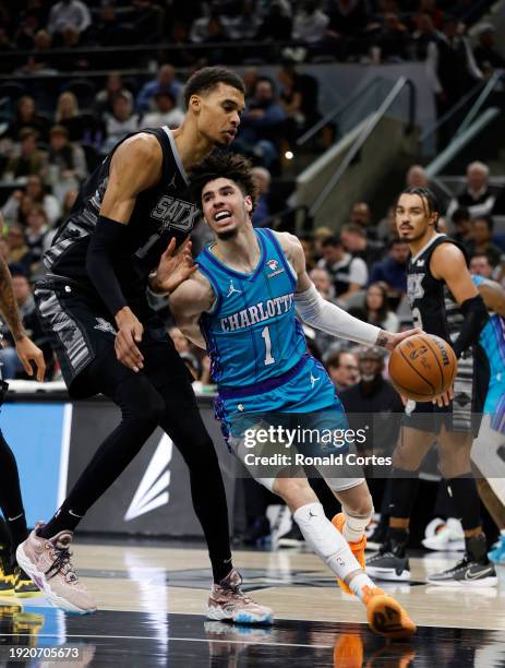 Victor Wembanyama of the San Antonio Spurs guards LaMelo Ball of the Charlotte Hornets in the first half at Frost Bank Center on January 12, 2024 in...