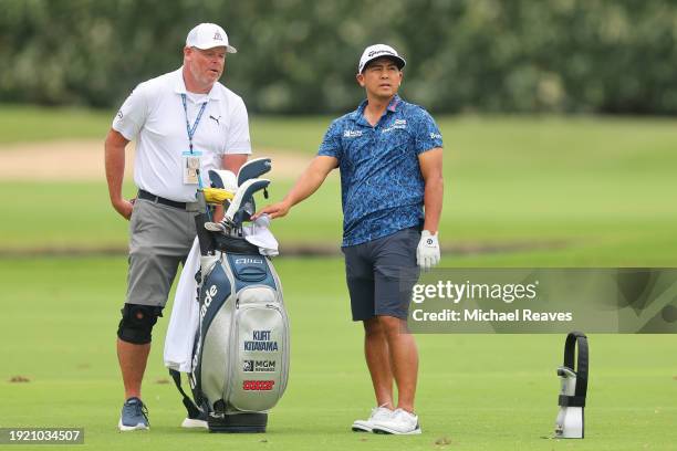 Kurt Kitayama of the United States talks with his caddie Tim Tucker on the fourth hole during a practice round prior to the Sony Open in Hawaii at...