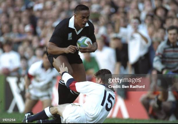 Jonah Lomu of New Zealand charges through the tackle of Mike Catt of England to score a try during the Rugby World Cup Semi Final at the Newlands...