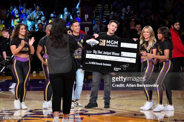 Fan hits a half-court shot to win a $100,000 MGM jackpot during a basketball game between the Los Angeles Lakers and the Toronto Raptors at...