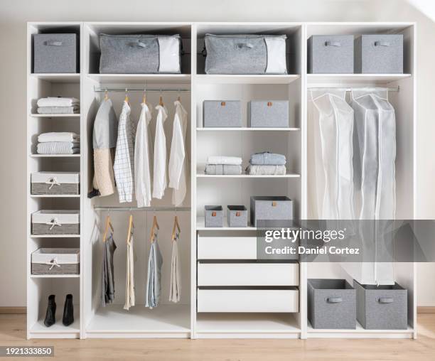 closet with different clothes and accessories, clothing cover in a modern white wardrobe organizer inside a modern room - wardrobe organisation stock pictures, royalty-free photos & images