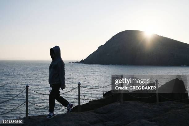 Man walks to a viewing point which overlooks the Taiwan Strait, on Pingtan Island, in China's southeast Fujian province, the closest point in China...