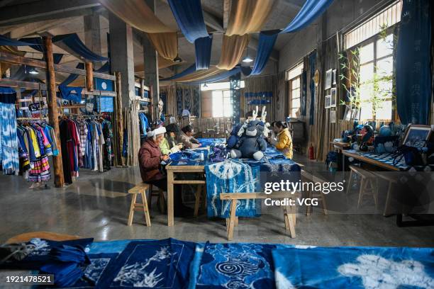 Craftswomen make batik decorations of the Buyi or Bouyei ethnic group ordered for the upcoming Chinese Spring Festival at a workshop on January 10,...