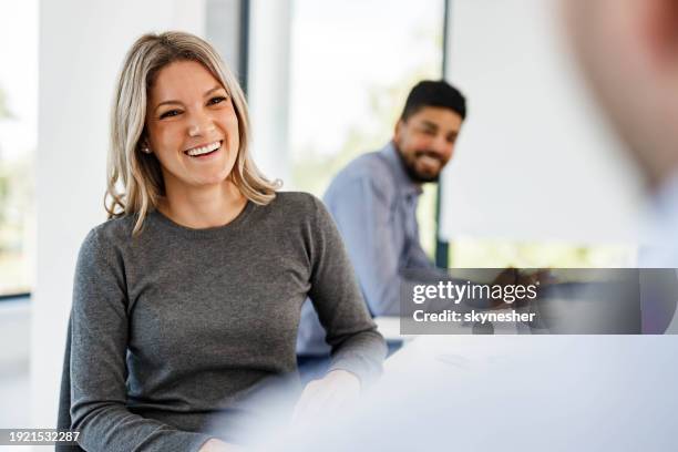 feliz empresaria hablando con sus colegas en la oficina. - vestimenta casual fotografías e imágenes de stock