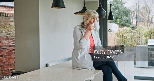 woman, drinking coffee and smartphone or relaxing in kitchen, online conversation and social media. happy mature person, hot beverage and internet connection or mobile app for communication at home - food and drink icon stock pictures, royalty-free photos & images