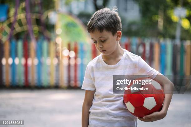 little boy feeling lonely - football toy stock pictures, royalty-free photos & images