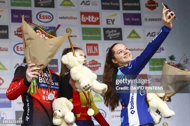 Belgian Shanyl De Schoesitter, Belgian Ilken Seynave and Belgian Alexe De Raedemaeker pose for a selfie picture as they celebrate on the podium after...