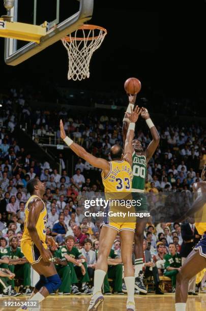 Robert Parish, Center for the Boston Celtics makes a jump shot to the basket over the blocking attempt of Kareem Abdul-Jabbar, Center for the Los...