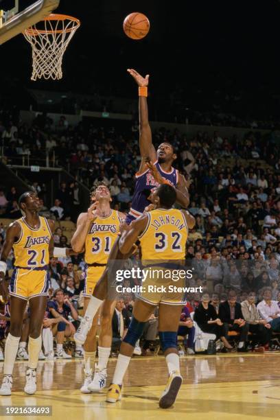 Mike Sanders, Small Forward for the Phoenix Suns attempts a lay up shot to the basket over Magic Johnson, #31 Kurt Rambis and Michael Cooper of the...