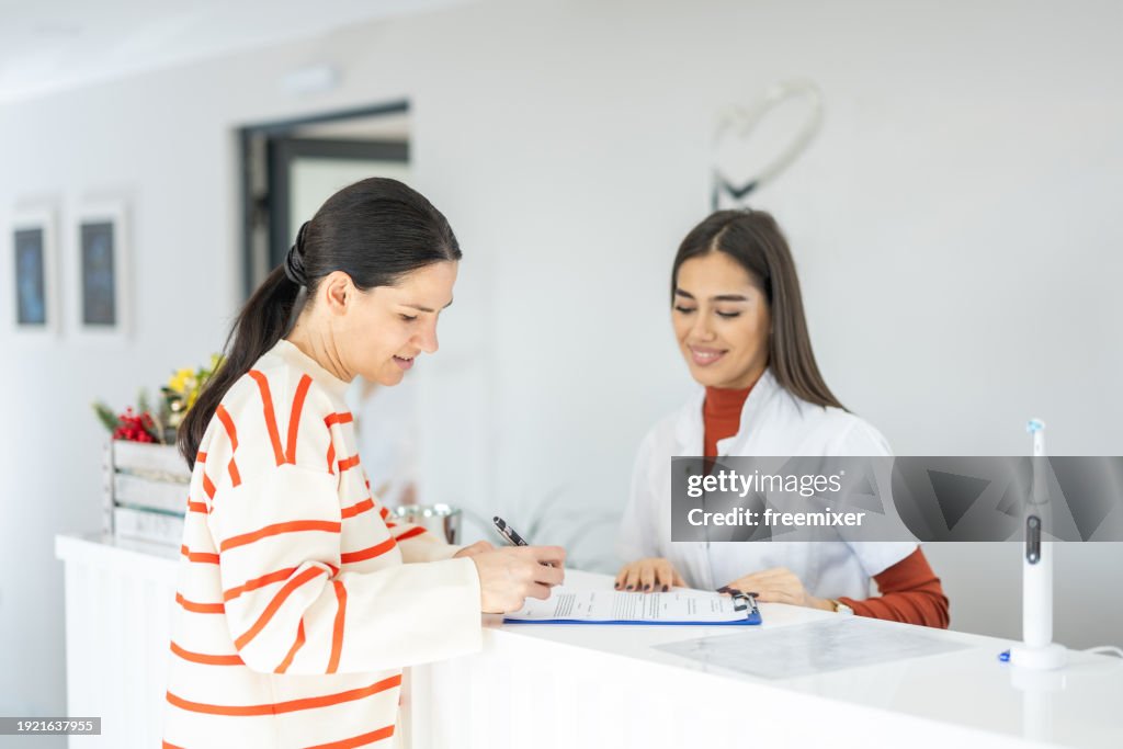 Patient signing documents in dental clinic