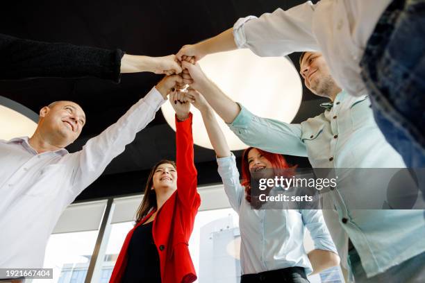 unified vision: business colleagues joining hands in unity, fostering team spirit in a creative luxury office setting - succession planning stock pictures, royalty-free photos & images