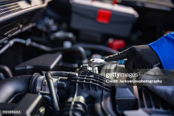 in the mechanic's garage, an auto mechanic is working on an engine. repair assistance. real close-up picture - part of vehicle stock pictures, royalty-free photos & images