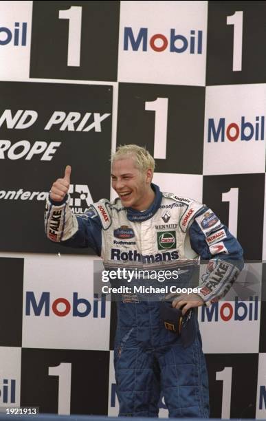 Williams Renault driver Jacques Villeneuve of Canada gives a thumbs up as he celebrates becoming World Champion Driver after the European Grand Prix...