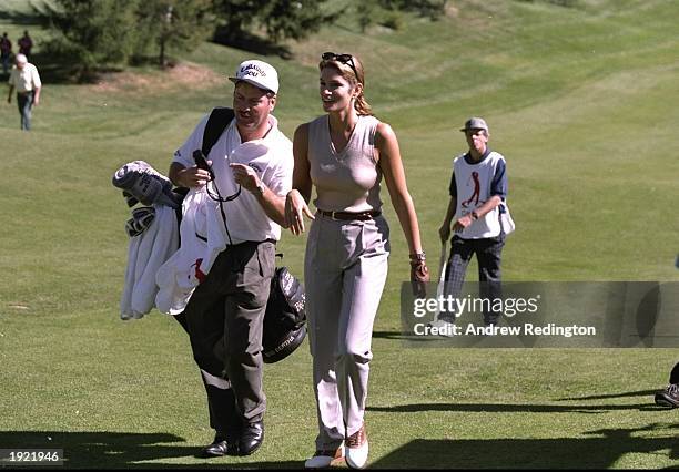 Supermodel Cindy Crawford of the USA walks up the fairway with Colin Montgomerie of Scotland's caddy during the Canon European Masters at the Crans...