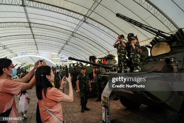 Thai soldier is posing with a child for photos on a military vehicle during National Children's Day inside a military base in Bangkok, Thailand, on...