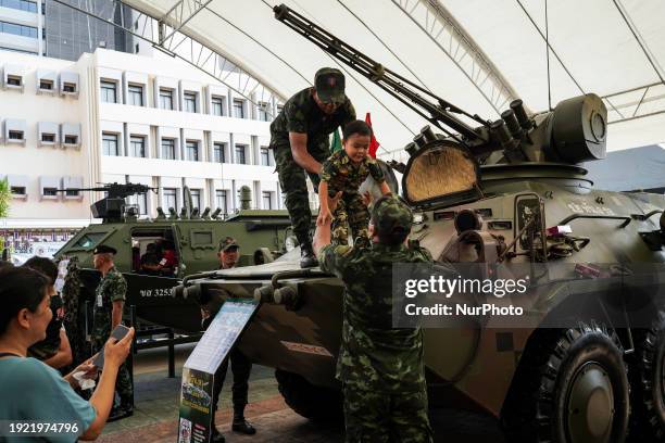 Thai child is posing for photos on a military vehicle during National Children's Day inside a military base in Bangkok, Thailand, on January 13, 2024.