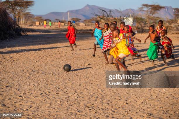 afrikanische kinder spielen fußball in einem dorf im norden kenias, ostafrika - poor kids playing soccer stock-fotos und bilder