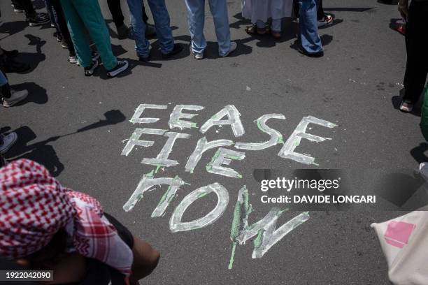 General view of the words 'cease fire now' written on the road during a Pro-Palestinian gathering in front of the US Consulate in Sandton,...