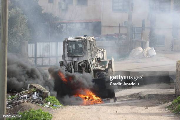 Palestinians burn tires and block roads in response to the Israeli raid on Al-Far'a Refugee Camp, Israeli forces use excavator bucket in an attempt...