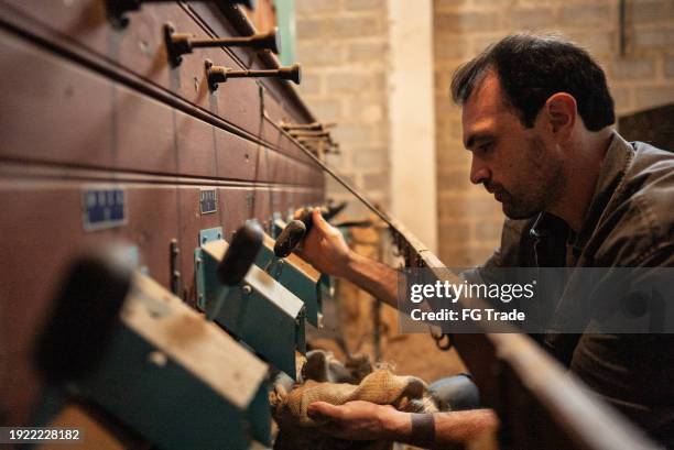 farmer working on an agricultural equipment at a farm - coffee manufacturing stock pictures, royalty-free photos & images