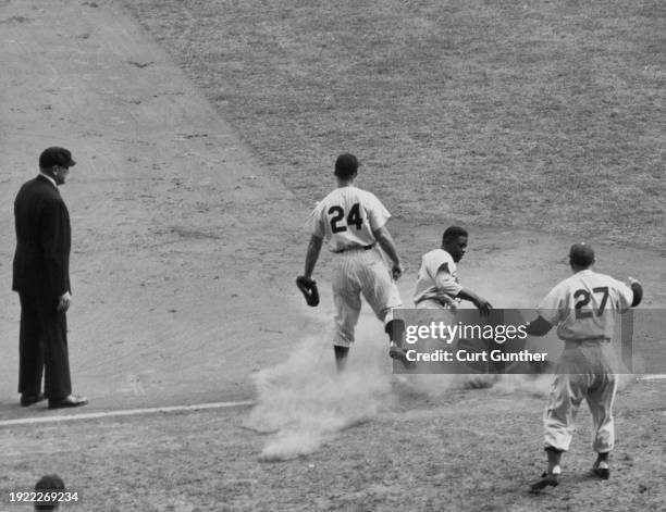 Jackie Robinson Second Baseman for the Brooklyn Dodgers slides into 3rd base as Bill Johnson, Third Baseman for the New York Yankees, #27 Milt Stock,...