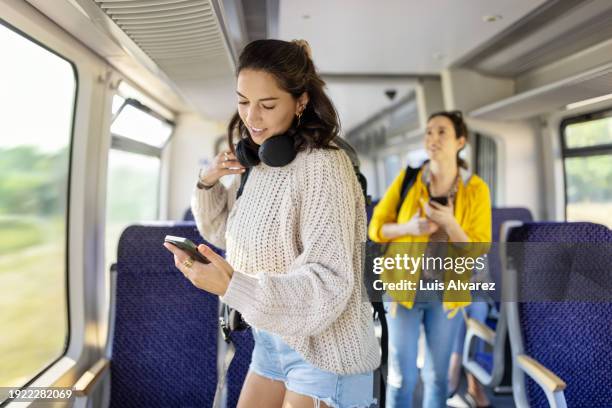 woman travellers searching their seats in train coach - bahnwaggon innenansicht stock-fotos und bilder