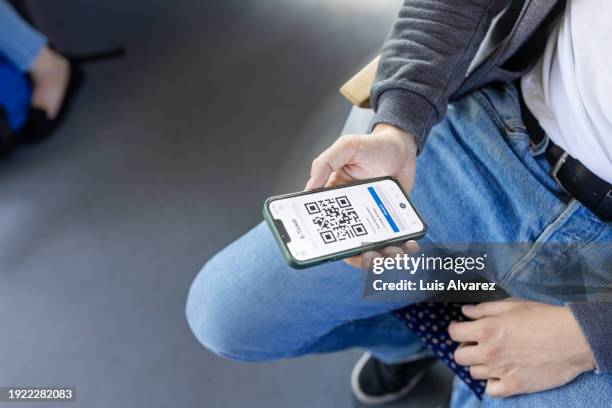 man looking at electronic ticket on mobile phone screen in train - train ticket stock pictures, royalty-free photos & images