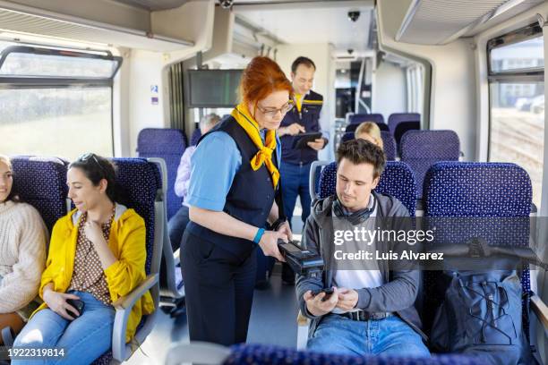 Woman Conductor Checking Ticket Of Male Passenger Using Bar Code Reader ...