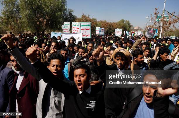 Yemeni university students lift the Palestinian flag and shout slogans during a protest held against the Israeli war's countinuation and the...