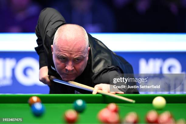 John Higgins of Scotland plays a shot during his first round match against Mark Allen of England on day four of the MrQ Masters Snooker 2024 at...