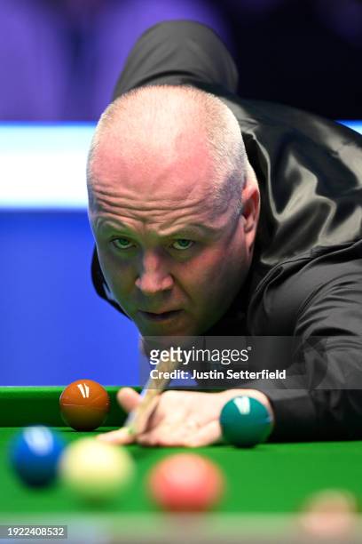 John Higgins of Scotland plays a shot during his first round match against Mark Allen of England on day four of the MrQ Masters Snooker 2024 at...