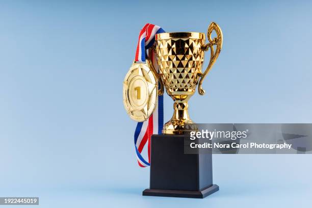 gold trophy award and medal on blue background - cup awards gala stock pictures, royalty-free photos & images