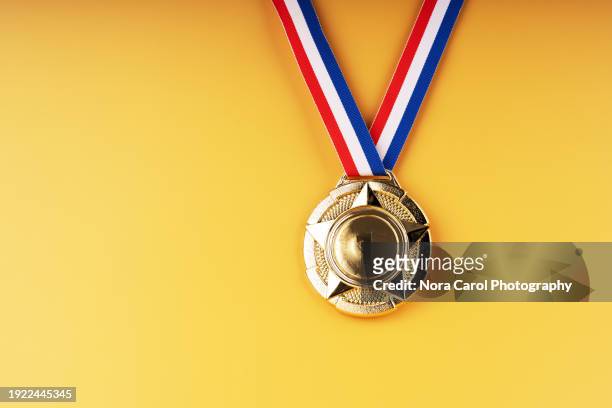 gold medal on yellow background - olympic ceremony stock pictures, royalty-free photos & images