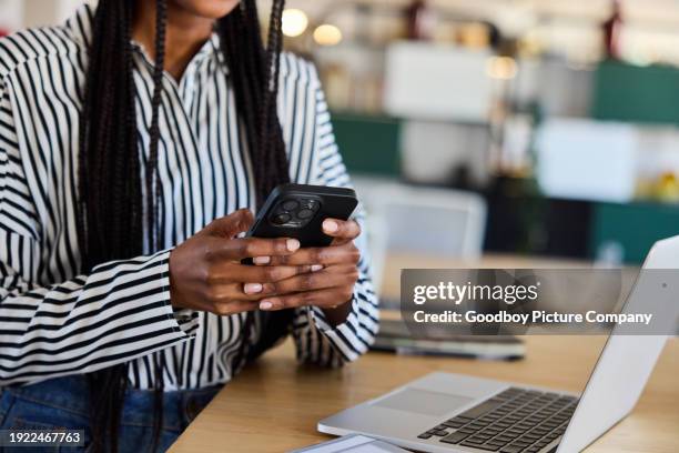 young businesswoman texting on her phone at an office desk - file sharing stock pictures, royalty-free photos & images