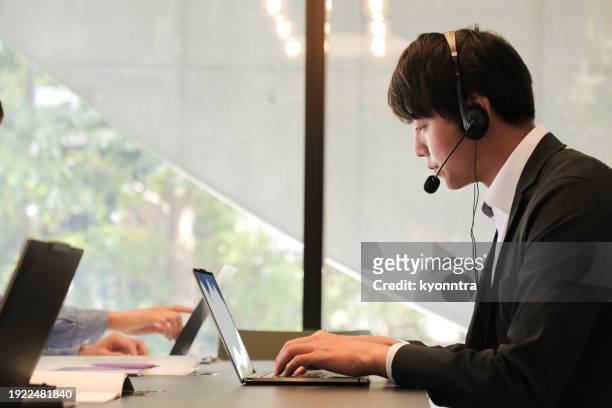 male customer service agent helping to support his customers - コールセンター　日本 ストックフォトと画像