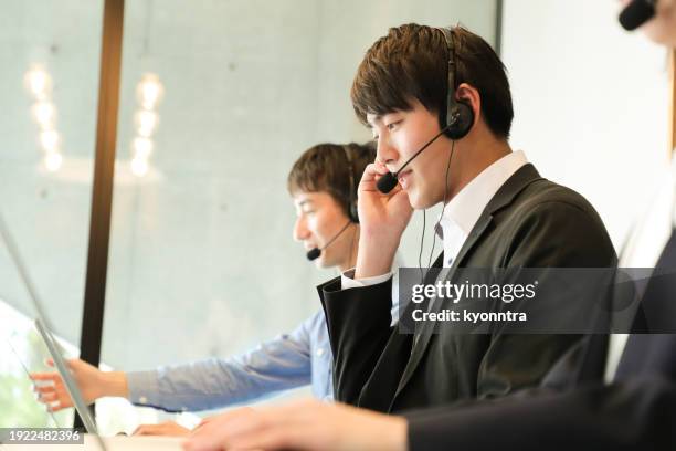 male customer service agent helping to support his customers - コールセンター　日本 ストックフォトと画像