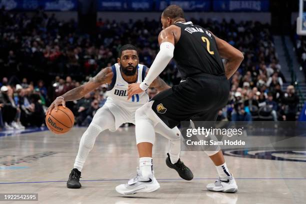 Kyrie Irving of the Dallas Mavericks controls the ball as Xavier Tillman of the Memphis Grizzlies defends during the first half at American Airlines...