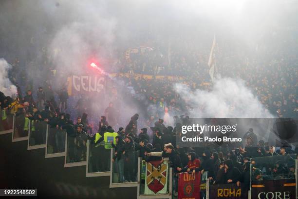 Fans of AS Roma throw flares in the stands prior to the Coppa Italia match between SS Lazio and AS Roma at Stadio Olimpico on January 10, 2024 in...