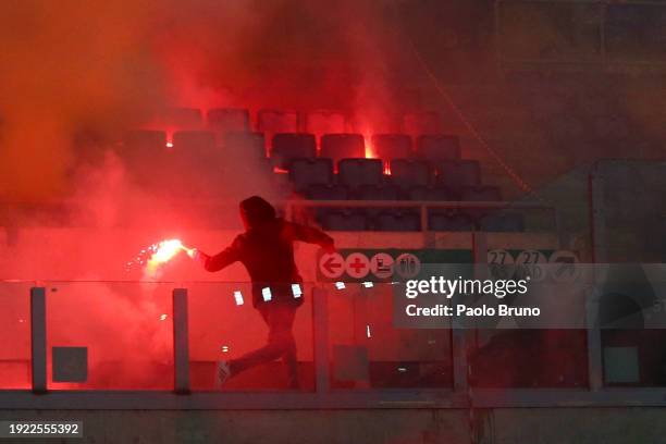 Fan of SS Lazio throws a flare in the stands prior to the Coppa Italia match between SS Lazio and AS Roma at Stadio Olimpico on January 10, 2024 in...