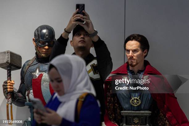 Man is taking a selfie with a collection of action figures at a superhero-themed hangout called Iconic Arcade in Sleman, Yogyakarta, Indonesia, on...