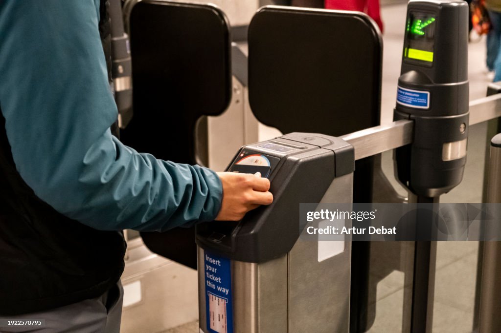 Young boy paying with contactless wallet in the subway station of London.