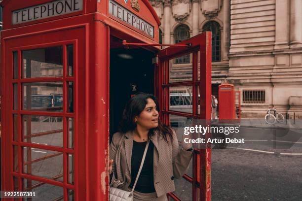 tourist woman with the famous telephone booth in london. - telefonzelle stock-fotos und bilder